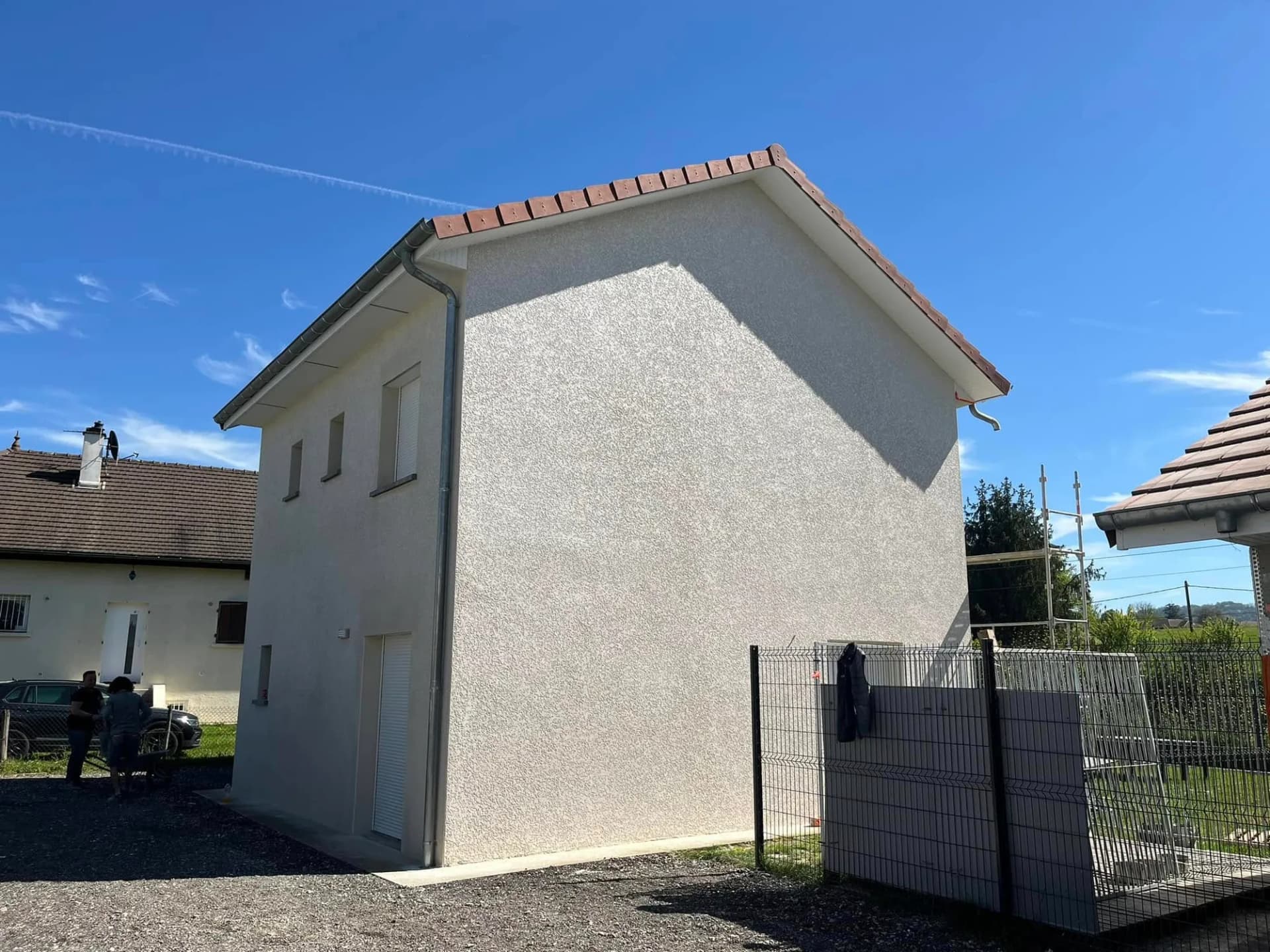 Pignon de maison neuve après ravalement, enduit monocouche appliqué, finition propre