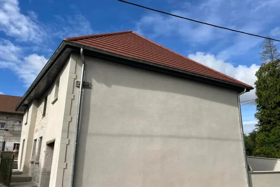 Pignon de maison en pisé après enduit à la chaux, vue depuis la route