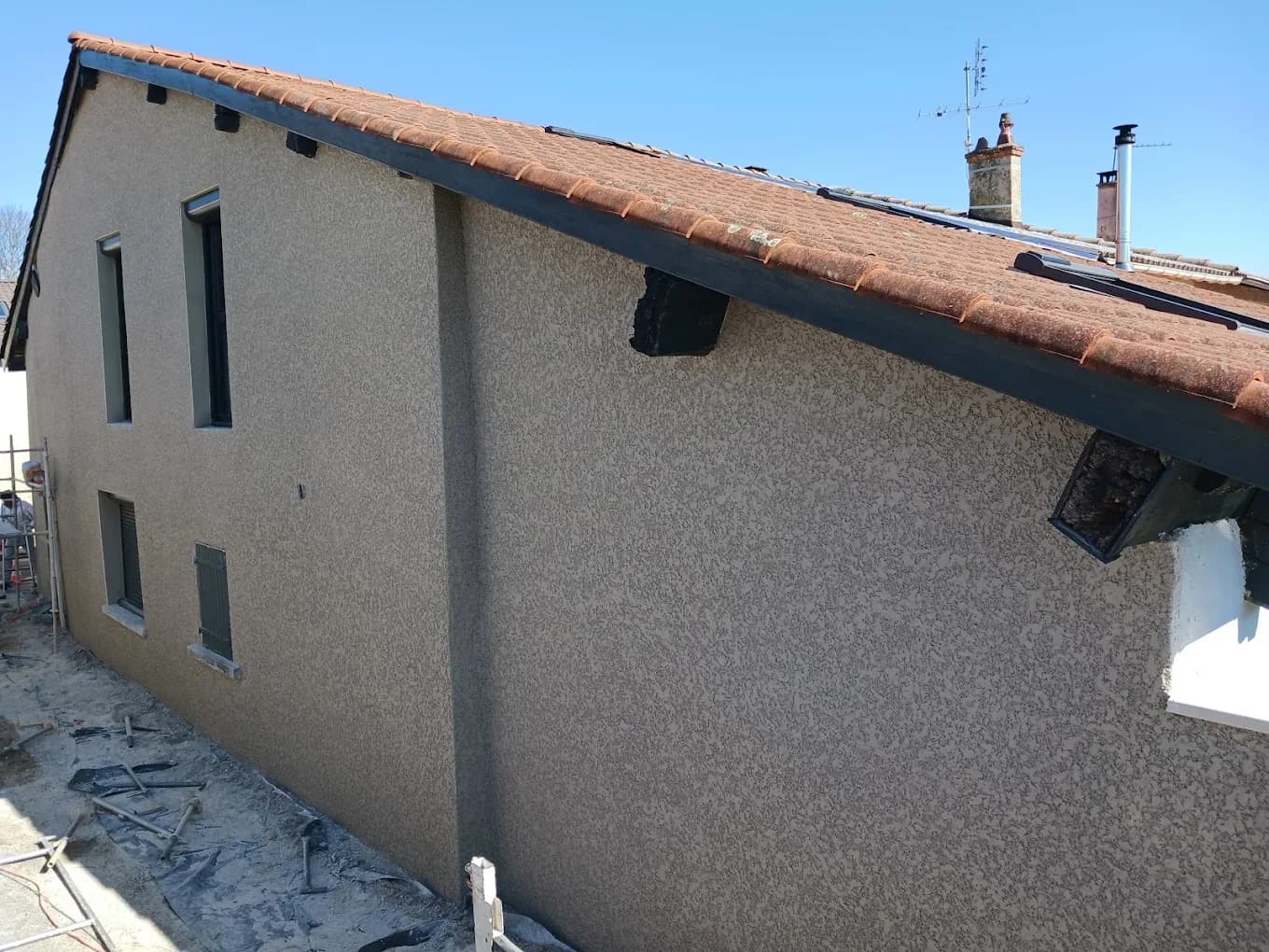 Maison ancienne après ravalement, enduit gris-brun, prise de vue depuis le toit voisin