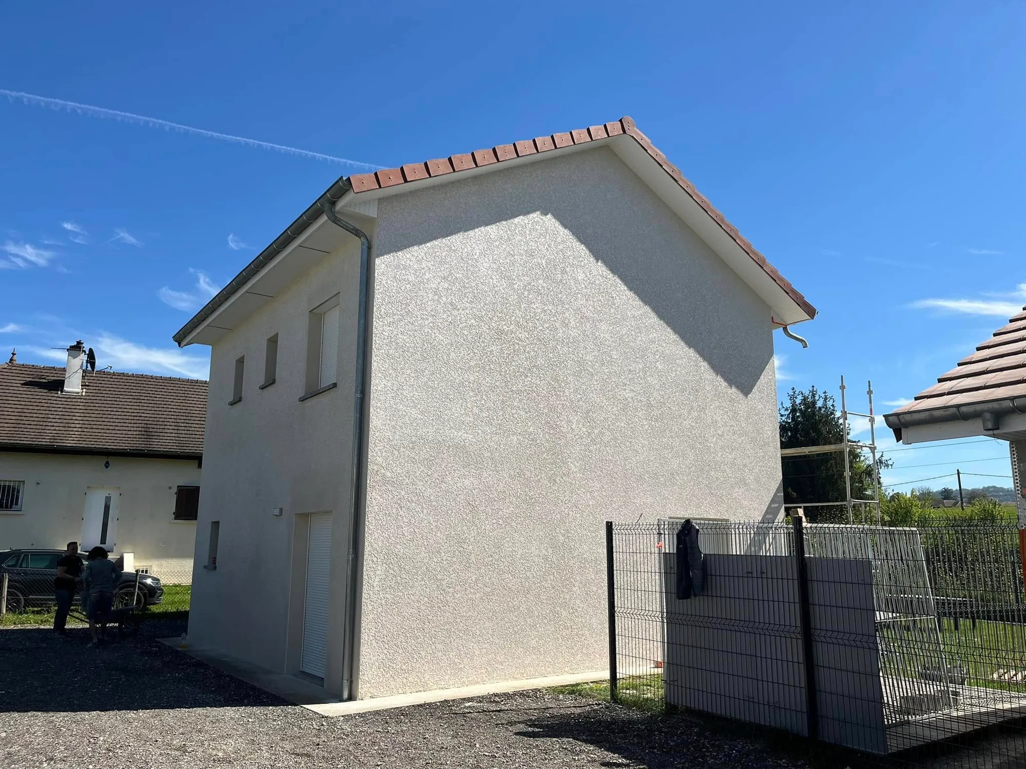 Pignon de maison neuve après ravalement, enduit monocouche appliqué, finition propre